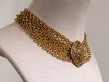 a close up of a mannequin with a gold chain necklace on it