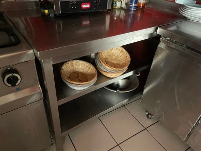 plan de travail en acier inoxydable muni de paniers, dans une cuisine professionnelle