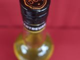 a close up of a bottle of liquor on a red surface