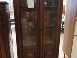 une grande armoire avec une porte vitrée au milieu d'une pièce