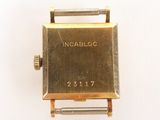 a gold watch that is sitting on a white surface