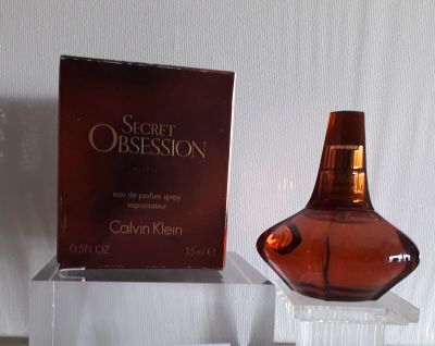 un flacon de parfum posé sur une table à côté d'une boîte