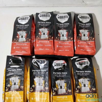 six bags of coffee sit on a table next to a bag of coffee