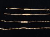 four different types of gold bracelets on a black background