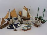 beaucoup de petits modèles réduits de bateaux posés sur la table