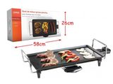 un gros plan sur un barbecue posé sur une table, avec une boîte en arrière-plan