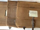 three leather cases sitting on top of a white sheet