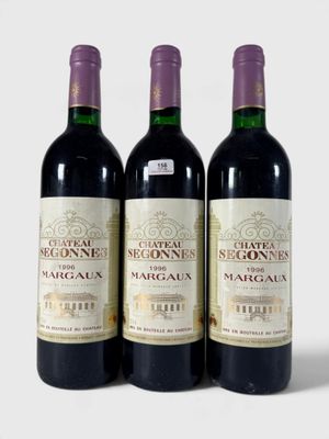 trois bouteilles de vin posées les unes à côté des autres sur une surface blanche