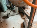 a cement mixer sitting on the floor next to a pile of garbage