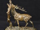 a bronze statue of a stag with antlers in a tree