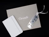 un coffret cadeau ouvert, orné d'un ruban blanc et d'une étiquette argentée