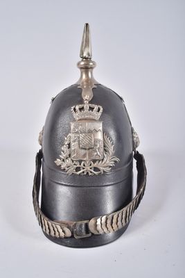 un vieux casque surmonté d'une couronne, posé sur une surface blanche