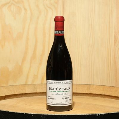 a bottle of wine sitting on top of a barrel