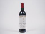 une bouteille de vin rouge posée sur une table blanche