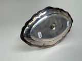 a silver plate on a white table with a tag on it