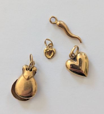 deux bijoux en or posés sur une surface blanche