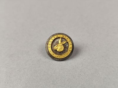 un gros plan d'un bouton orné d'un oiseau