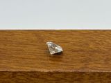 a small diamond on a wooden table with a white background