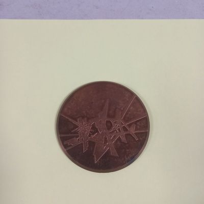 un petit bout de papier sur lequel figure une pièce de monnaie marron