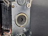 someone is holding an old camera in their hand on a black background