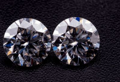 une paire de diamants taille ronde sur un fond noir