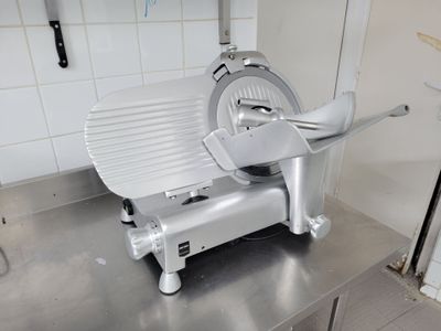 une photo d'une trancheuse à viande professionnelle dans une cuisine professionnelle