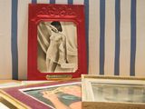 a picture of a picture of a woman in a red frame on a table next to a picture of a woman in a white dress
