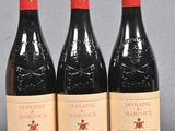 three bottles of red wine sitting on top of a table
