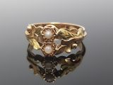 une image représentant une bague en or ornée de perles et de feuilles