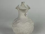 a white vase that has a bird on top of it