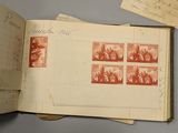 an open book sitting on top of a table next to a pile of stamps