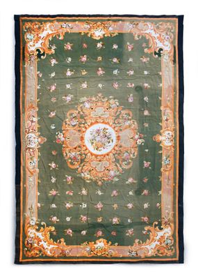 a green and orange rug with a floral design on it