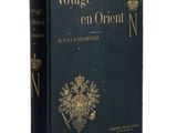 un livre noir orné d'un emblème doré, posé sur une surface blanche
