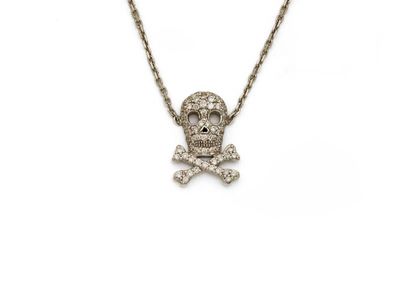 un gros plan d'un collier représentant un crâne et des os croisés sur fond blanc
