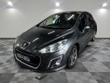 La voiture noire est garée sur le sol à damier du garage.