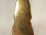 a gold spoon sitting on top of a white table