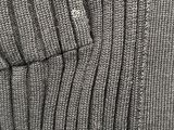 the sweater is gray and has a small button on it