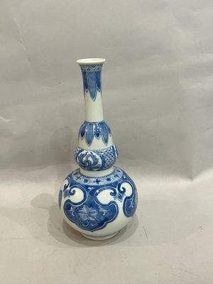 a blue and white vase with a fish design on it