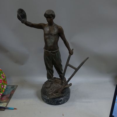 une statue représentant un homme tenant un gant de baseball et une balle