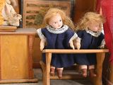 three dolls that are sitting on a small table