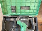a green box with a drill in it on a wooden floor