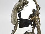 un miroir sur lequel figure un oiseau et une femme en robe