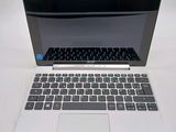 a white laptop with a black keyboard on a white table