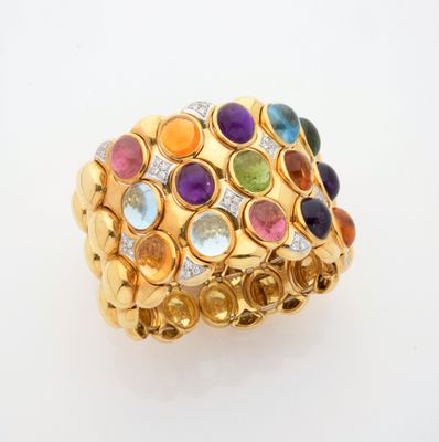 gros plan d'une bague en or avec des pierres multicolores