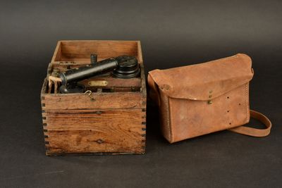 an old wooden box with a camera and a leather case