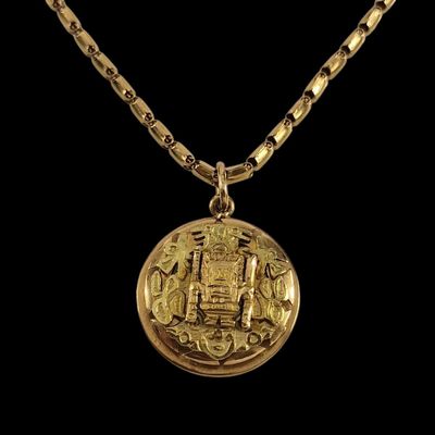 un collier en or avec une pièce de monnaie sur une chaîne