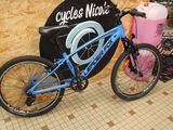 a bicycle that is parked next to a sign that says cycles nica