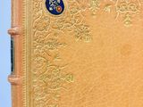 an old book with a gold cover on a blue background