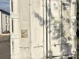 un grand conteneur blanc posé au bord de la route