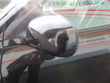 reflection of a man taking a picture of himself in the side view mirror of a car